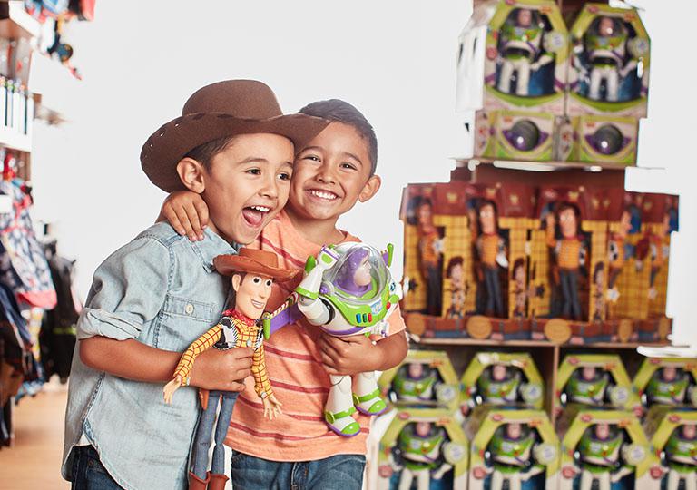 Children in Disney Store with Woody and Buzz Lightyear Action Figures