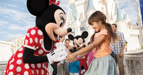 young girl excited to meet Minnie while family meets Mickey
