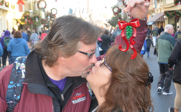 Couple at Disney kissing under mistletoe