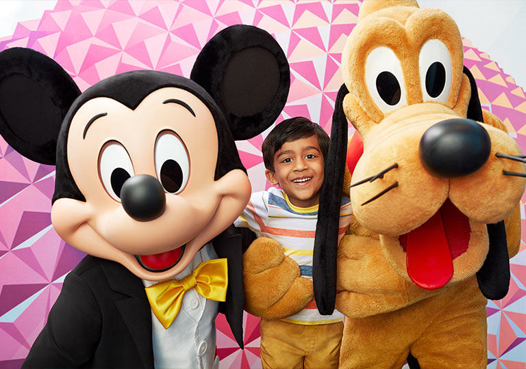 boy posing with Mikey and Pluto Disney