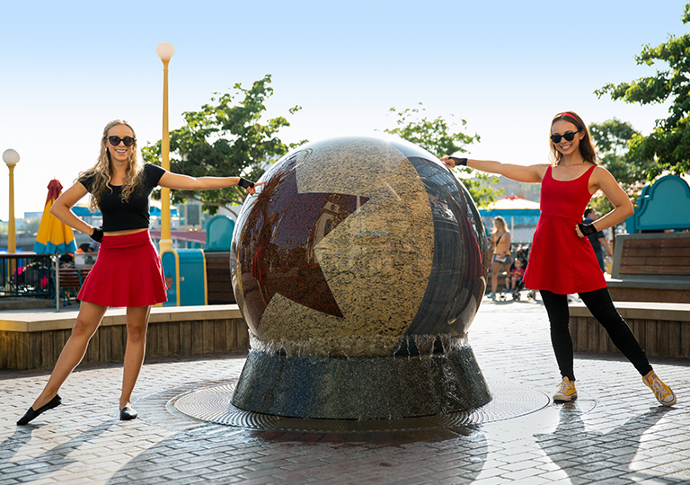 Girls posing next to Pixar Pier fountain