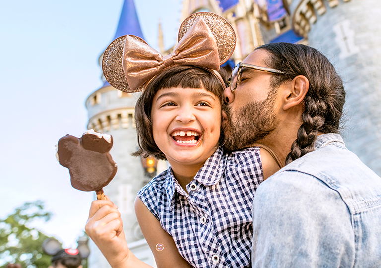 little girl and her dad eating Mickey’s Premium Ice Cream Bar