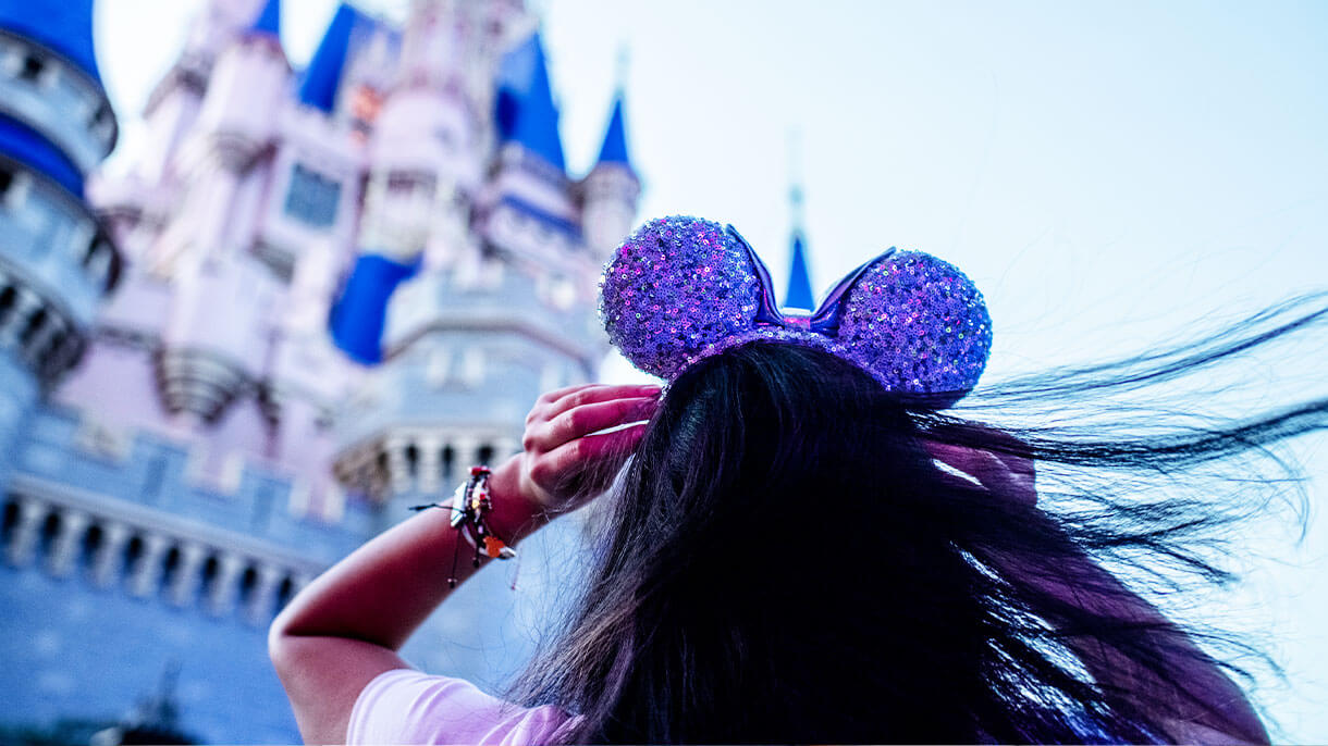 Girl with mickey ears in front of castle