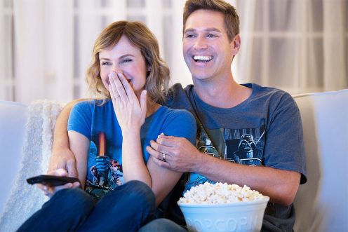 Couple eating popcorn and watching tv