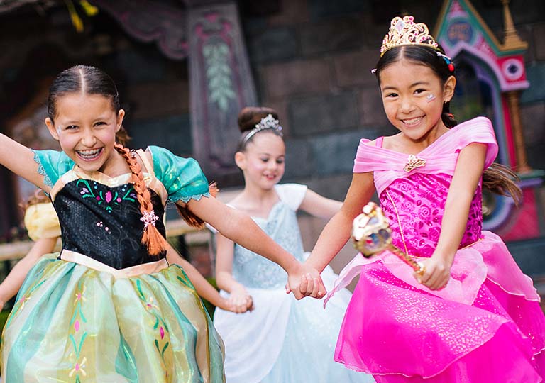 Girls holding hands in princess dresses