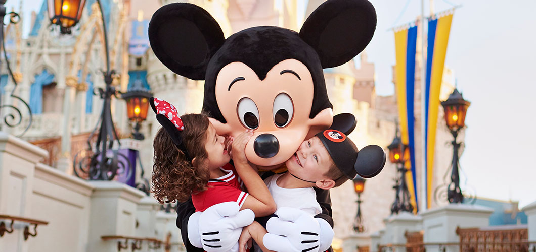 Kids hugging Mickey Mouse
