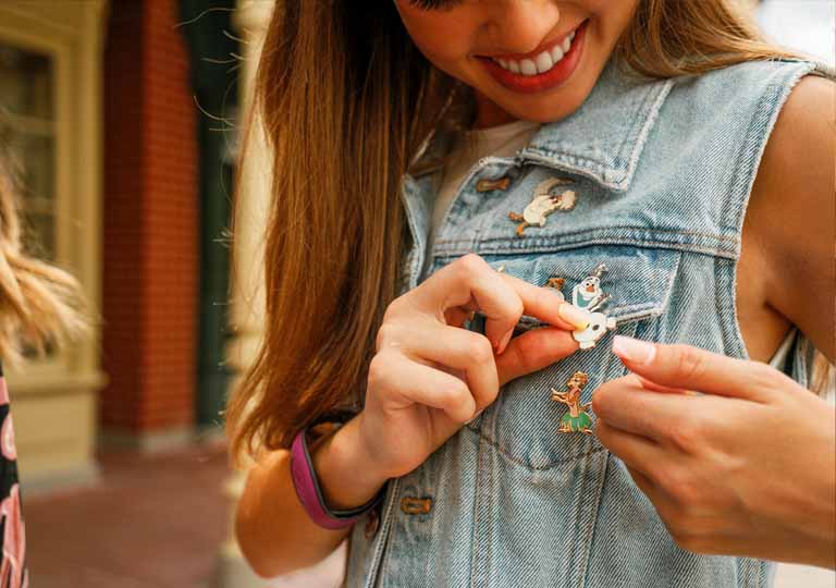 Girl pinning Olaf Pin onto her Jean Vest