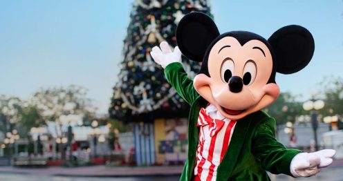 Mickey Mouse in front of a Christmas tree