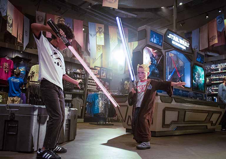 Kids with lightsabors at Star Wars Galactic Outpost