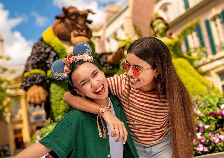 Friends in front of Beauty and the Beast topiaries during EPCOT Flower and Garden Festival