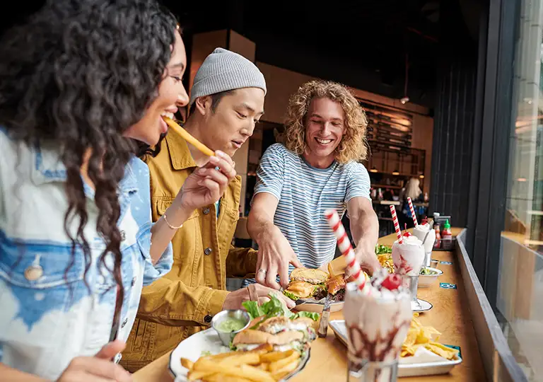 Group of friends eating burgers