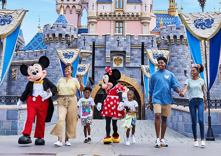 Guests in front of castle with Mickey Mouse and Minnie Mouse