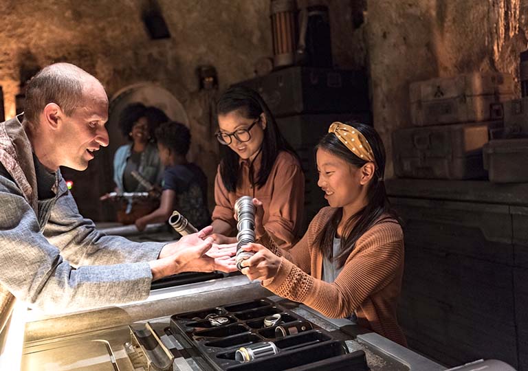 Girl with lightsabor at Savi's Workshop