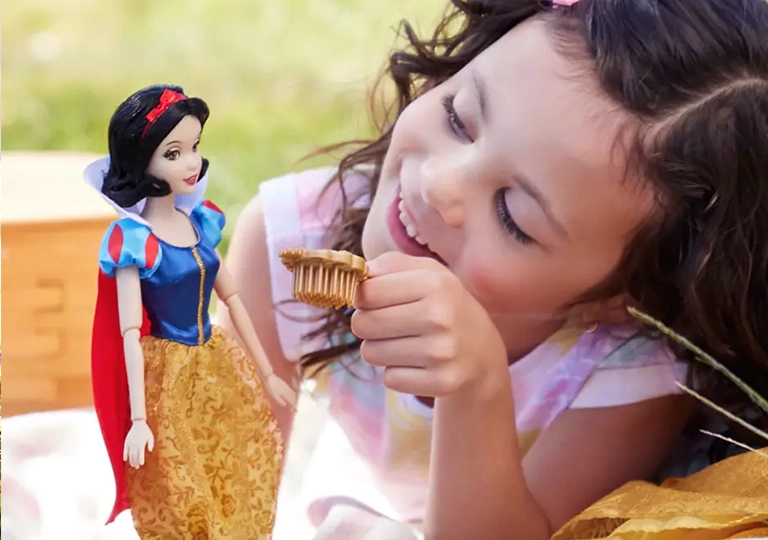 Girl playing with Snow White doll