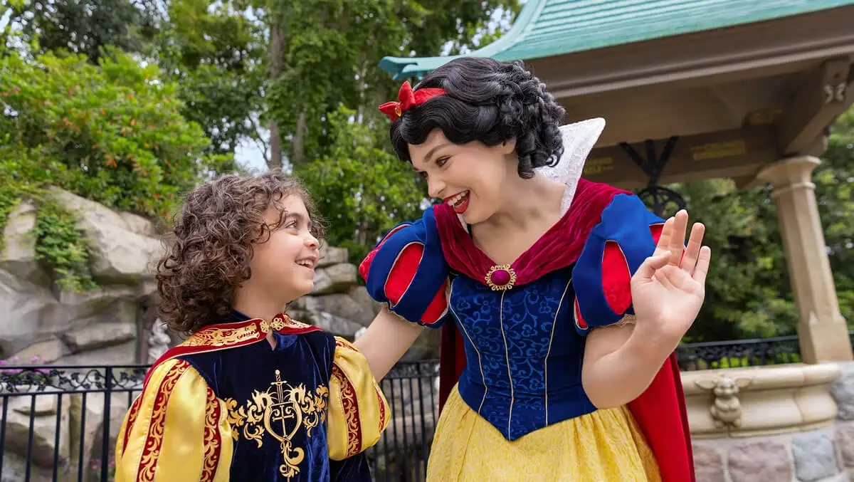 Snow White chatting with a toddler wearing a prince costume.
