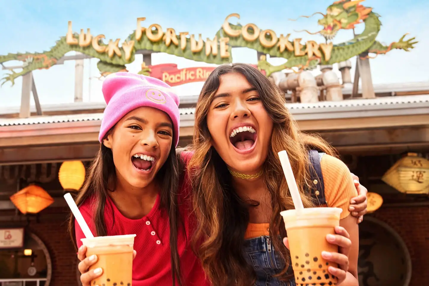 Two girls holding boba drinks at Lucky Fortune Cookery in Disney California Adventure Park.