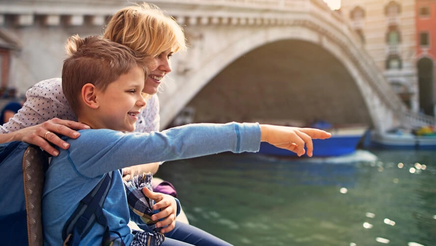 Disney mom and sun admiring Venice canal on a family trip to Italy.