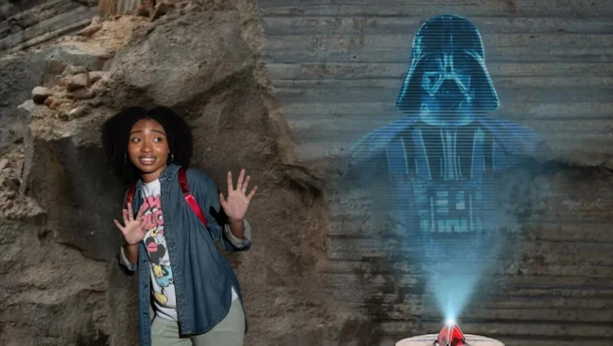Woman posing beside Darth Vader hologram at the Star Wars photo opportunity at Disney's Hollywood Studios.