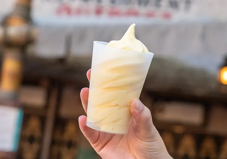 a hand holding a cup of DOLE Whip&reg;