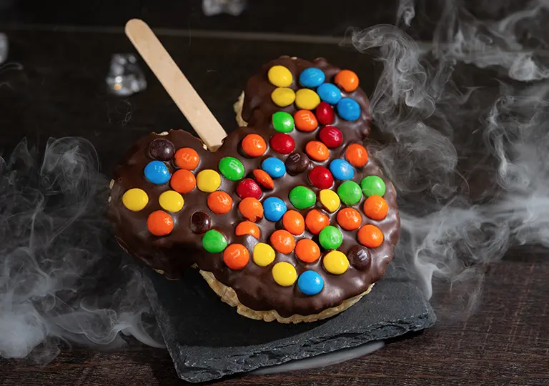 Mickey Rice Crispy Treat covered chocolate glaze topped with chocolate m&ms